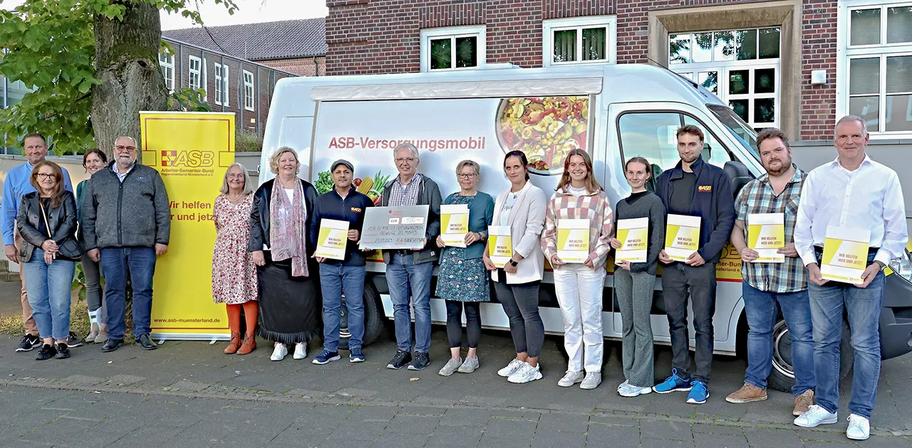 Ehrenamtliche des ASB Münsterland mit Urkunden „Freiwillige des Monats“ vor dem ASB-Versorgungsmobil, darunter das Team von Online-Profession
